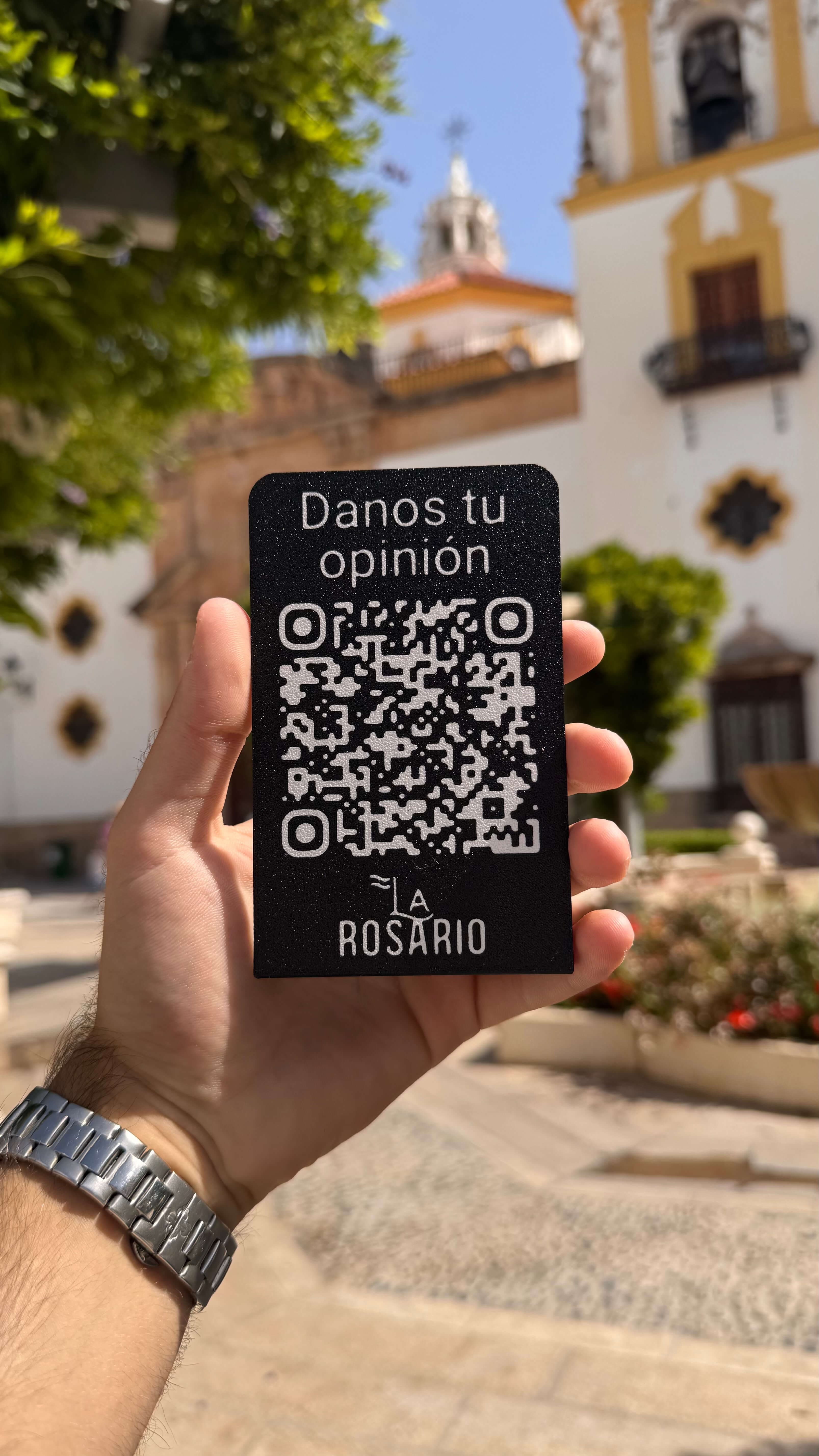 Placa personalizada en negro con el logo de La Rosario, sostenida al aire libre