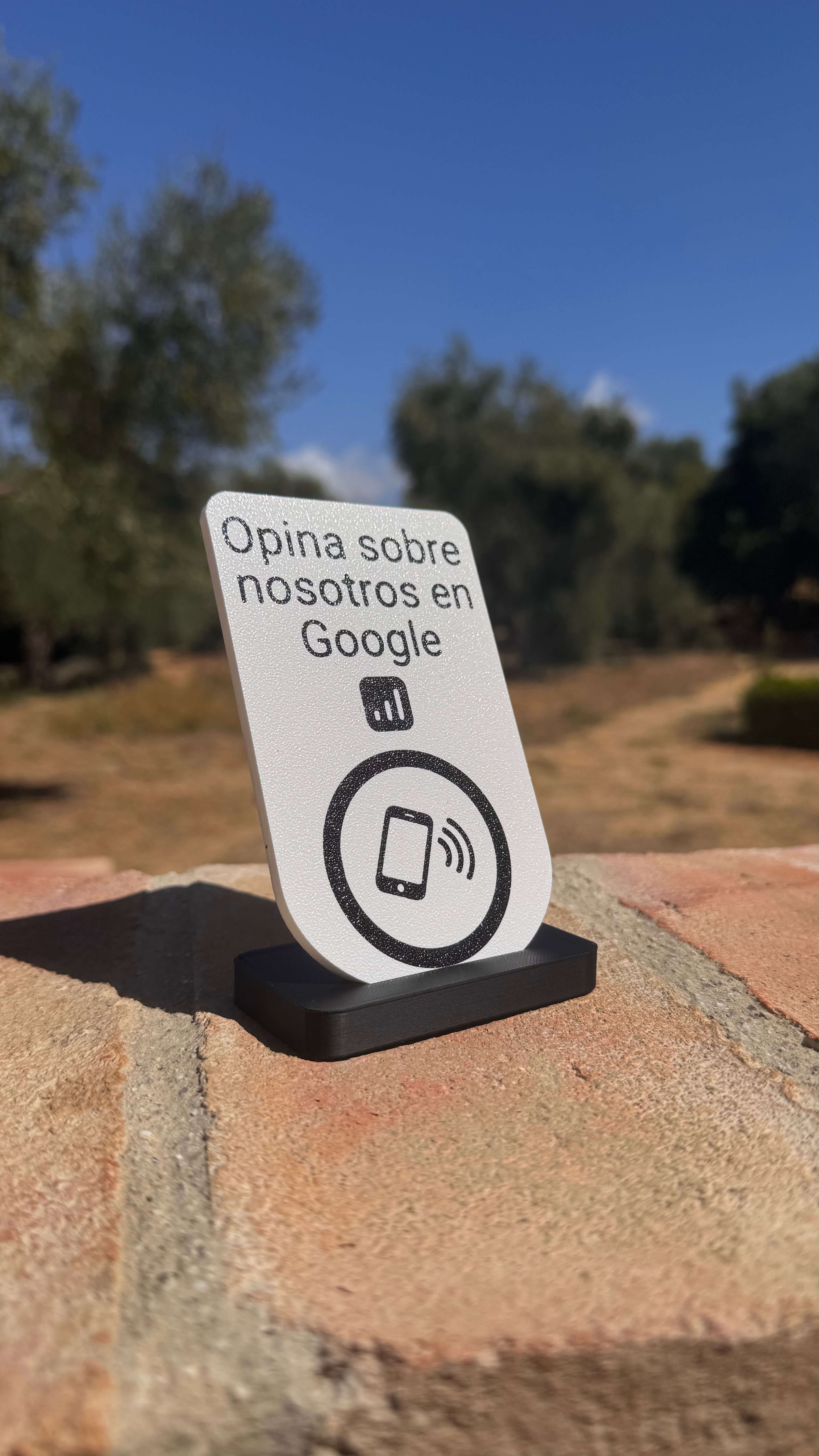 Placa NFC para reseñas en Google apoyada en su base al aire libre