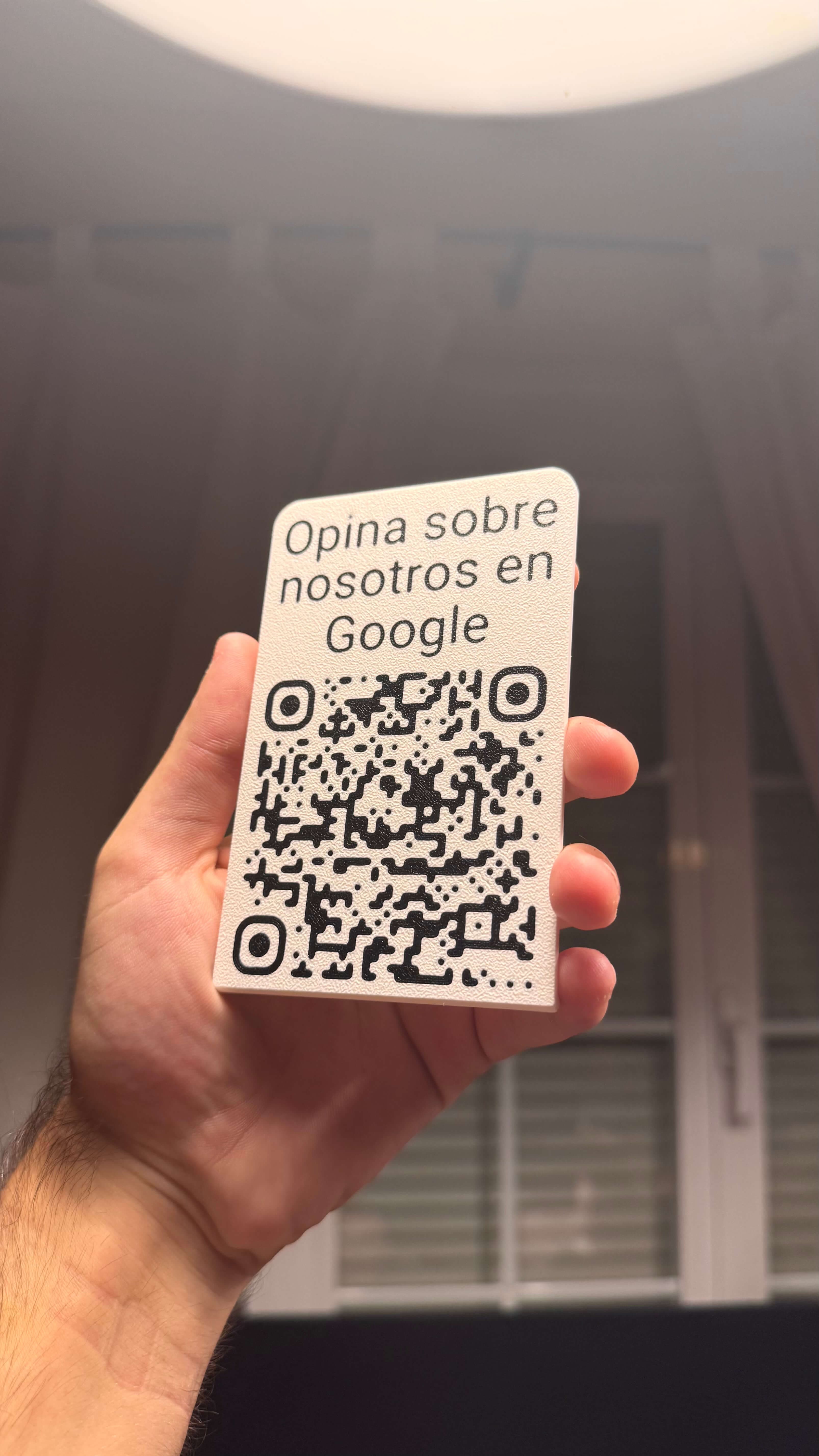 Stand QR de reseñas de Google colocado de pie sobre su base en un mostrador